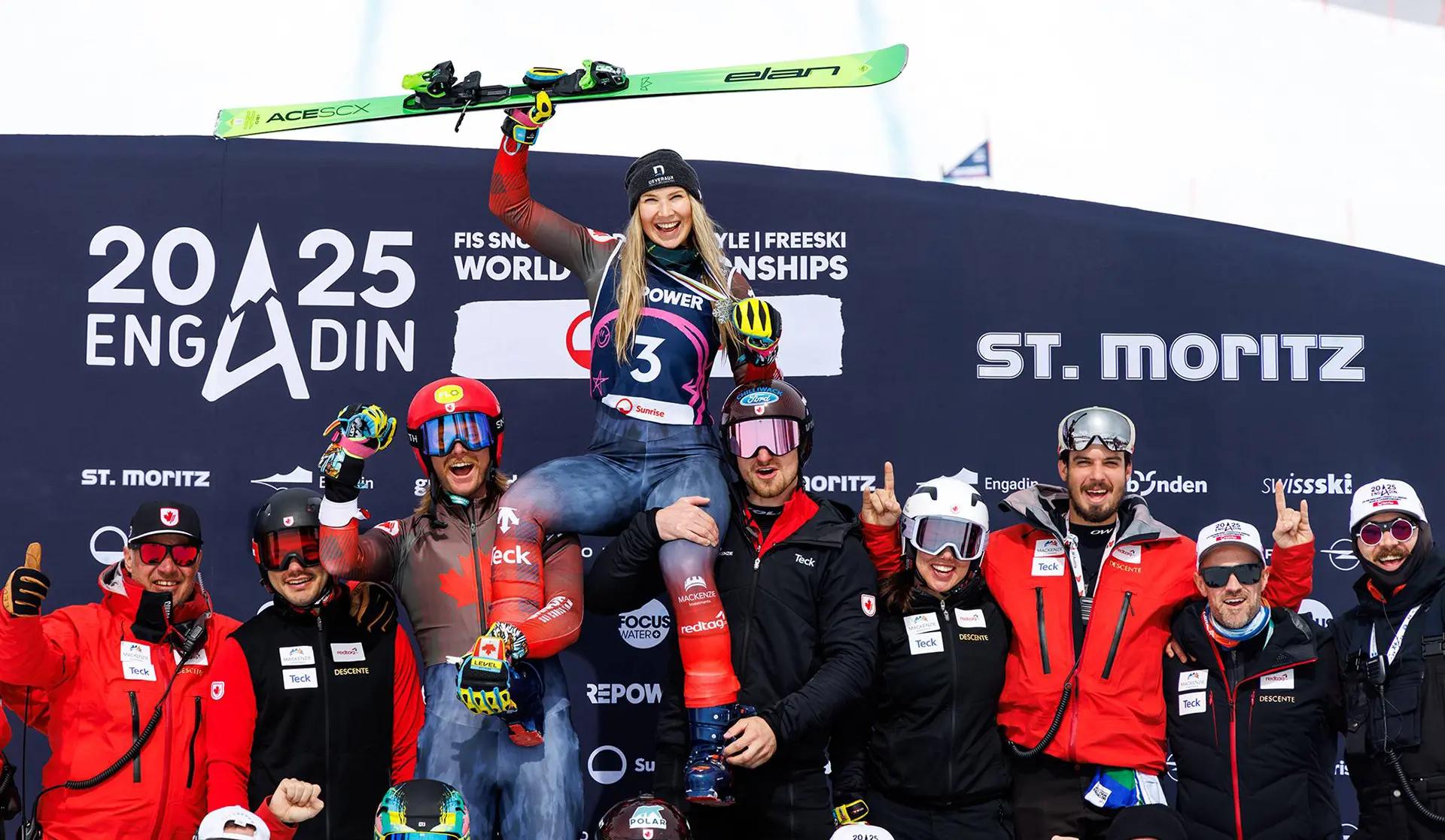 A large team photo with Courtney Hoffos being held up on their shoulders