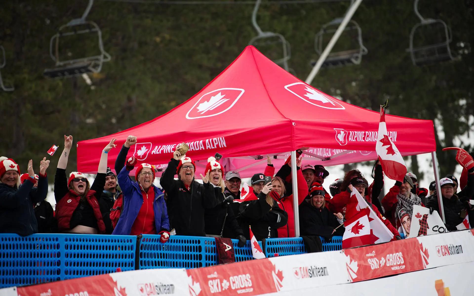 Canada supports wave flags by the Alpine Canada tent