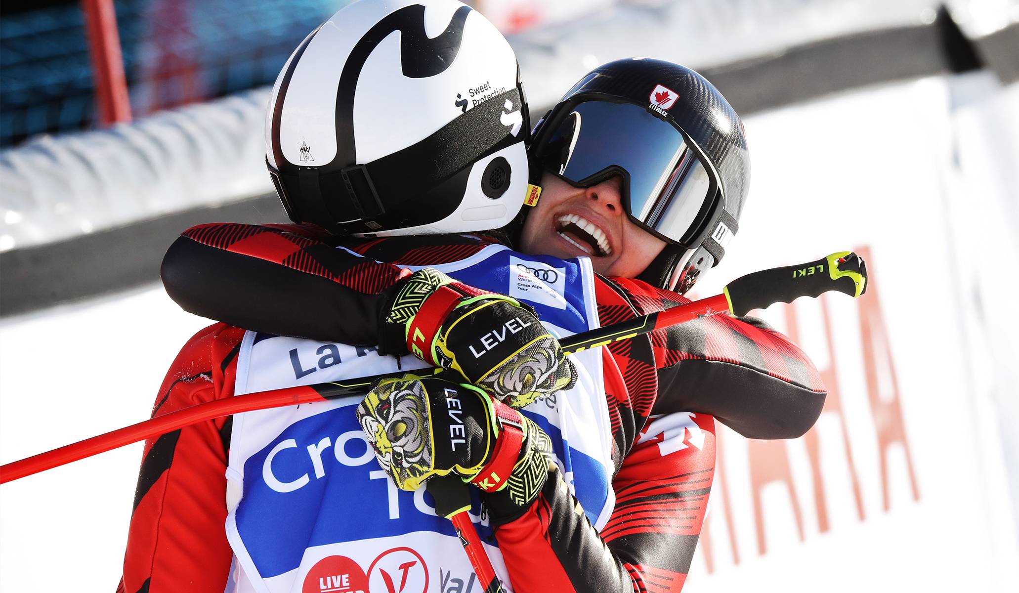 Impactful image of two ski athletes hugging happily after race