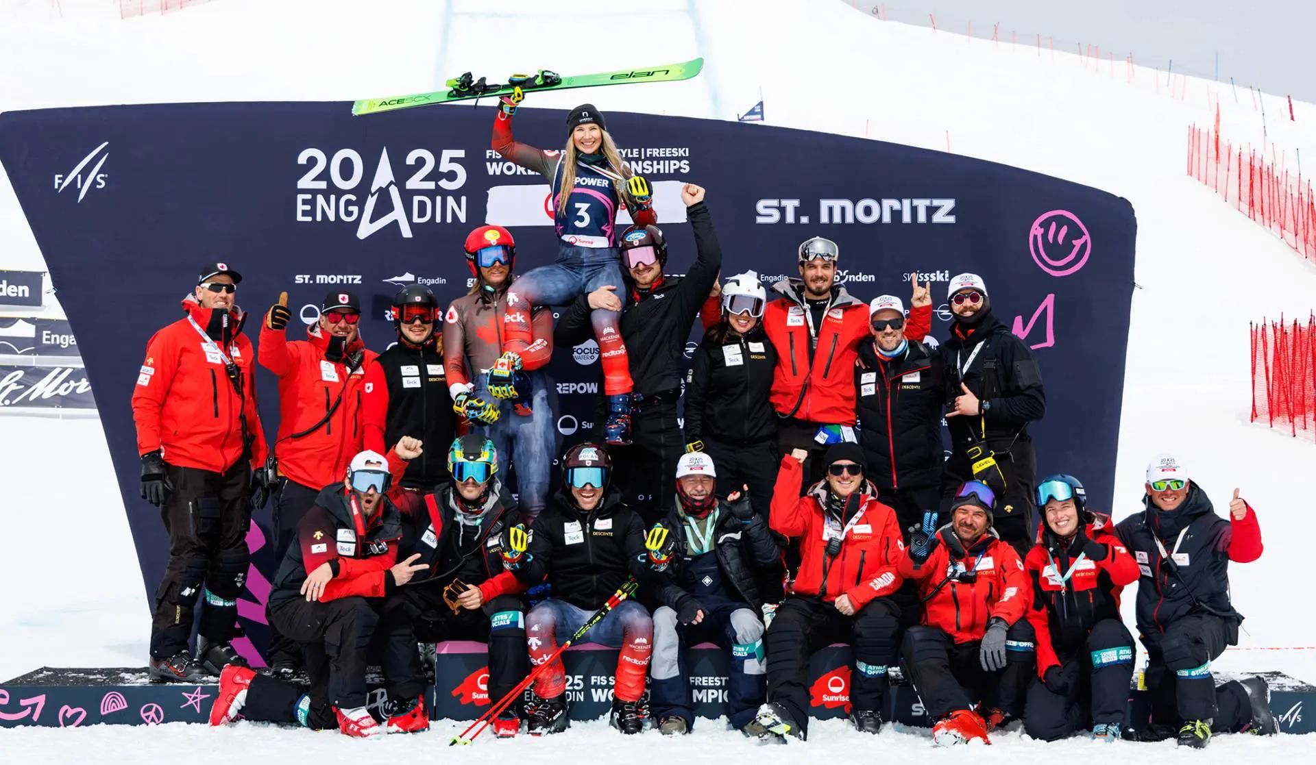A large team photo with Courtney Hoffos being held up on their shoulders