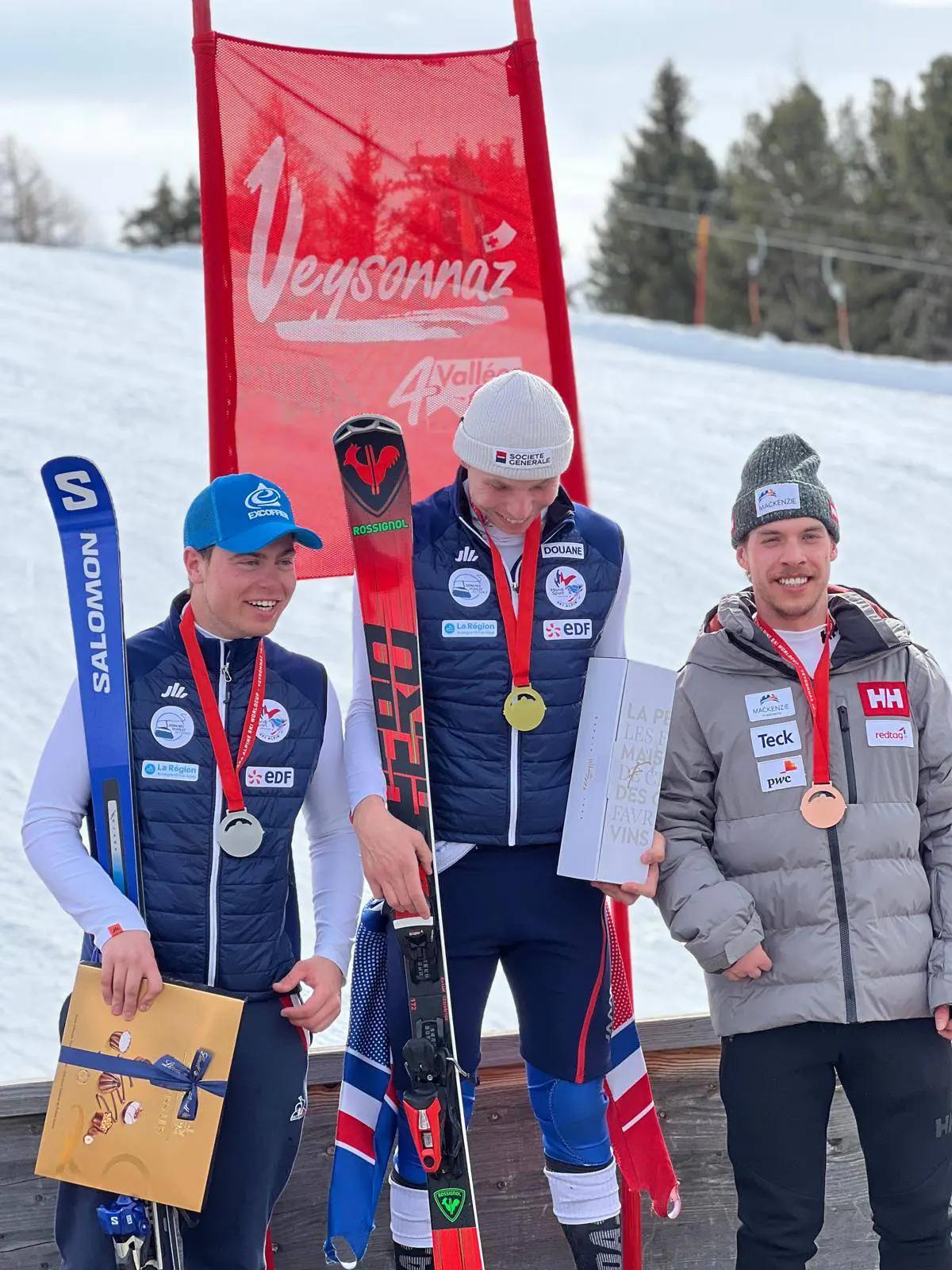 The smiling winners standing on the podium in front of the slops